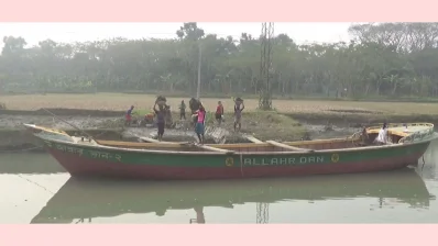 মাটি ভর্তি টুকরি মাথায় নিয়ে নৌকা তুলছে একদল শ্রমিক। ছবি: খবর সংযোগ