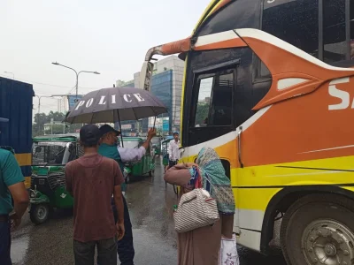 নির্দিষ্ট স্থান ছাড়া বাসে যাত্রী তুলতে নিষেধ করছেন ট্রাফিক পুলিশের এক সদস্য