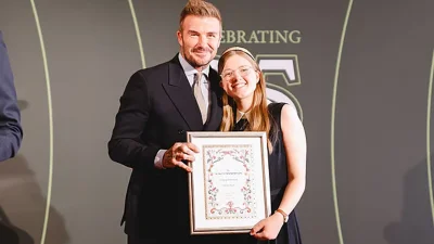 ফুটবল তারকা ডেভিড বেকহামের হাত থেকে পুরস্কার নিচ্ছেন এমিলি হার্স্ট। ছবি: সংগৃহীত