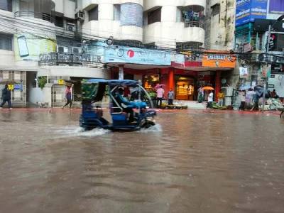রাজধানীর মালিবাগে ডুবে যাওয়া সড়কে আটোরিকশা নিয়ে ছুটছেন চালক। ছবি: সুলতান সোহান